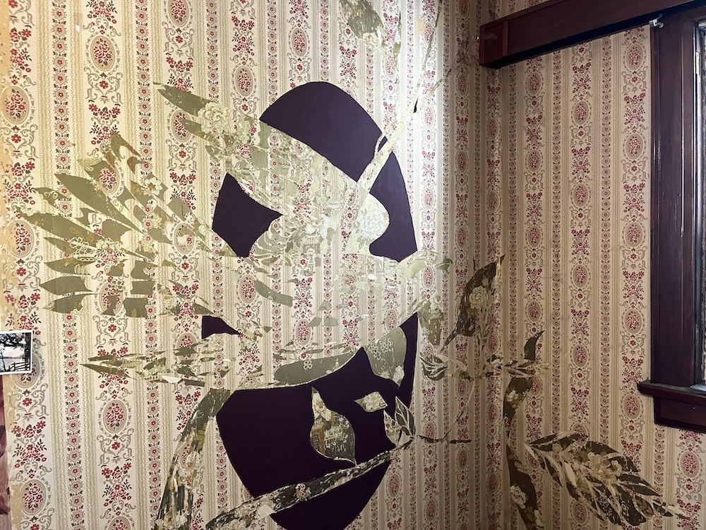 Moises aka Luvs discovered multiple layers of wallpaper throughout the home. A bird takes shape on the wall by carefully cutting and peeling the wallpaper.