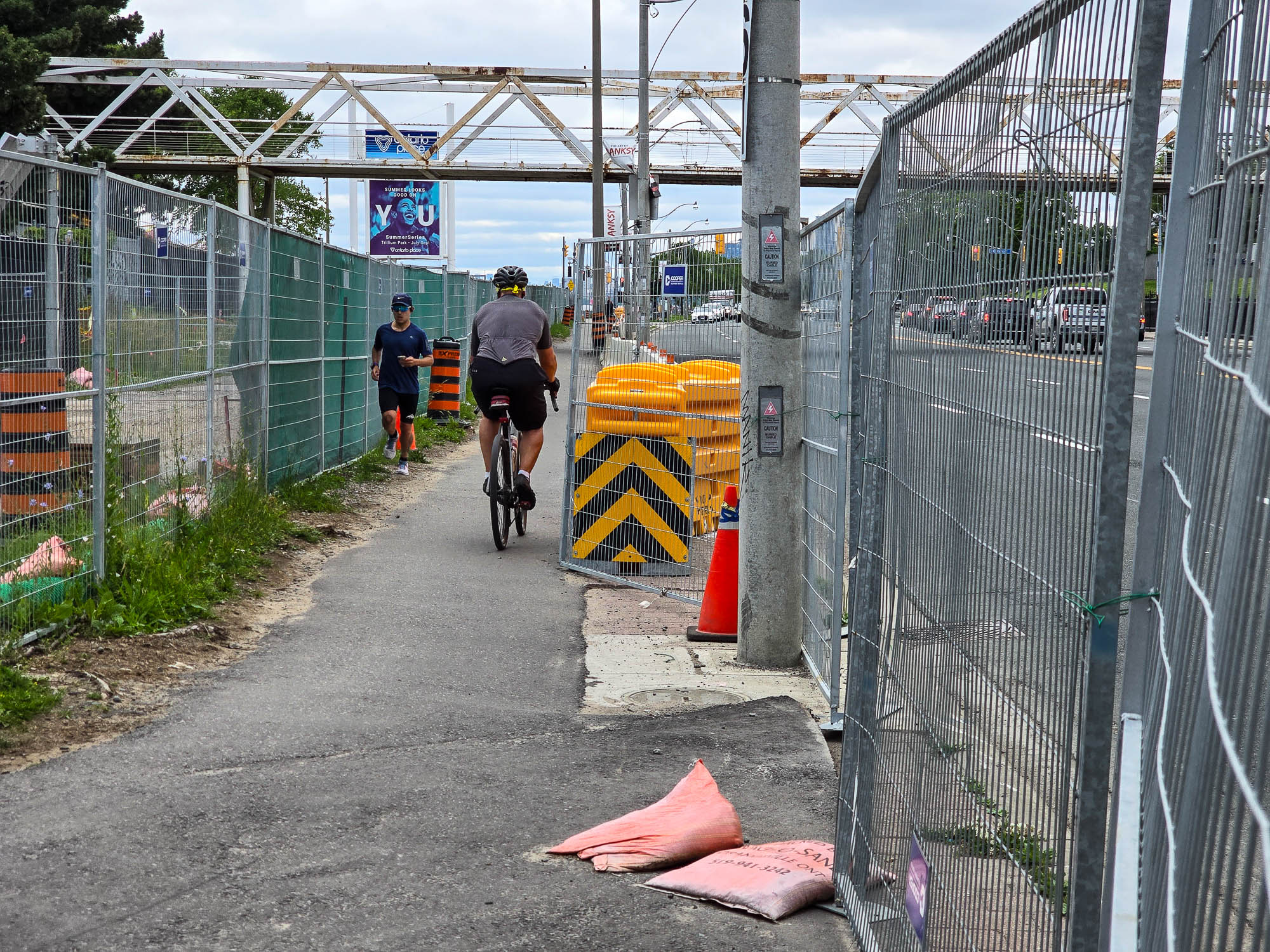 Contractors working on the Ontario Place redevelopment project have reduced the width of the busy Martin Goodman Trail to three feet in places, resulting in collisions between bicyclists, pedestrians, and runners. The trail is often strewn with construction debris. Prof. Steve Mann of Swim OP suffered a concussion when he had to swerve to avoid a collision and fell off his mobility scooter. (Photo: Steve Mann)