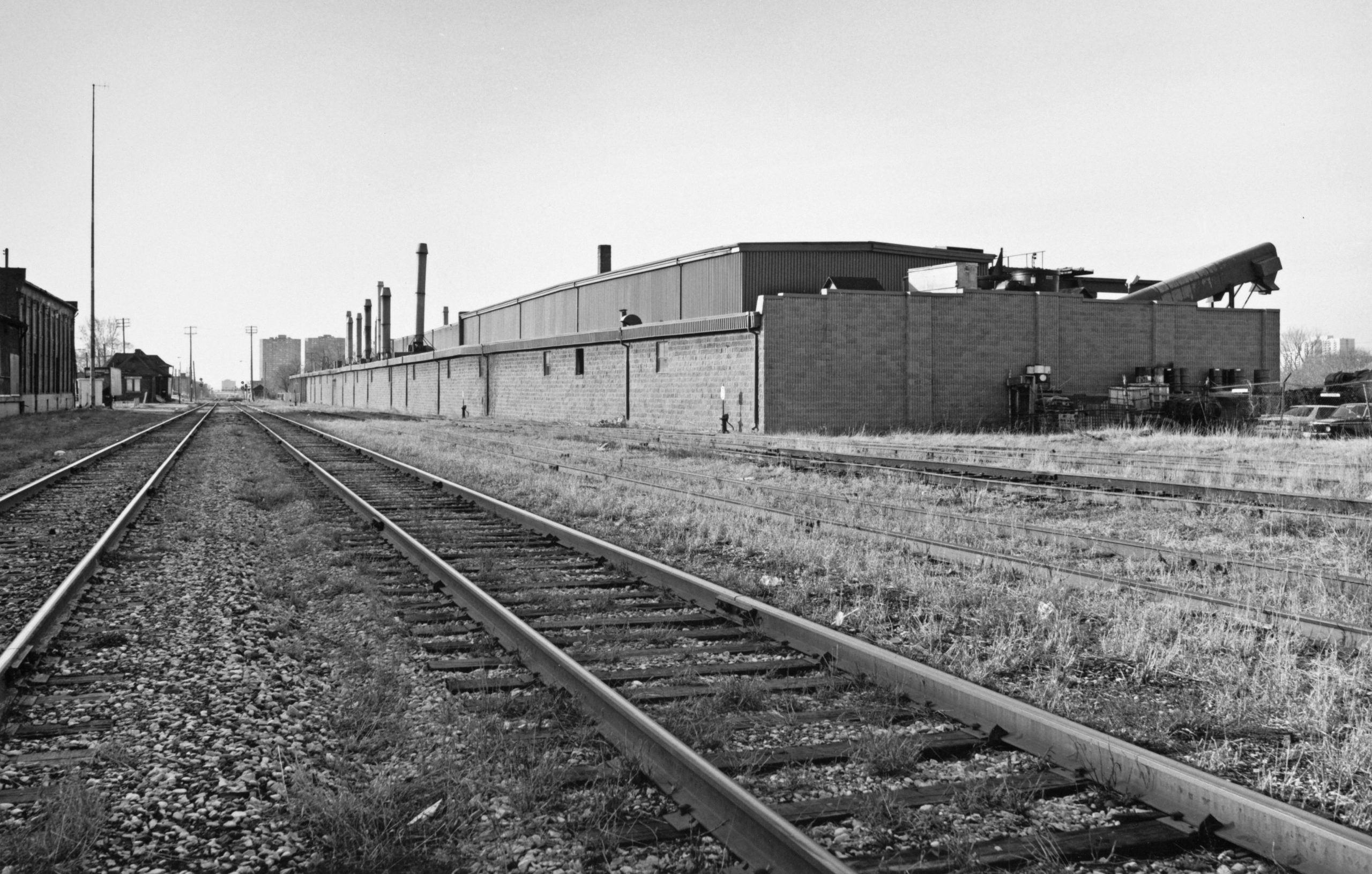 CN rail line. looking south toward Junction Road, April, 1993, National RubberIndustries on right, CN West Toronto station and freight shed on far left