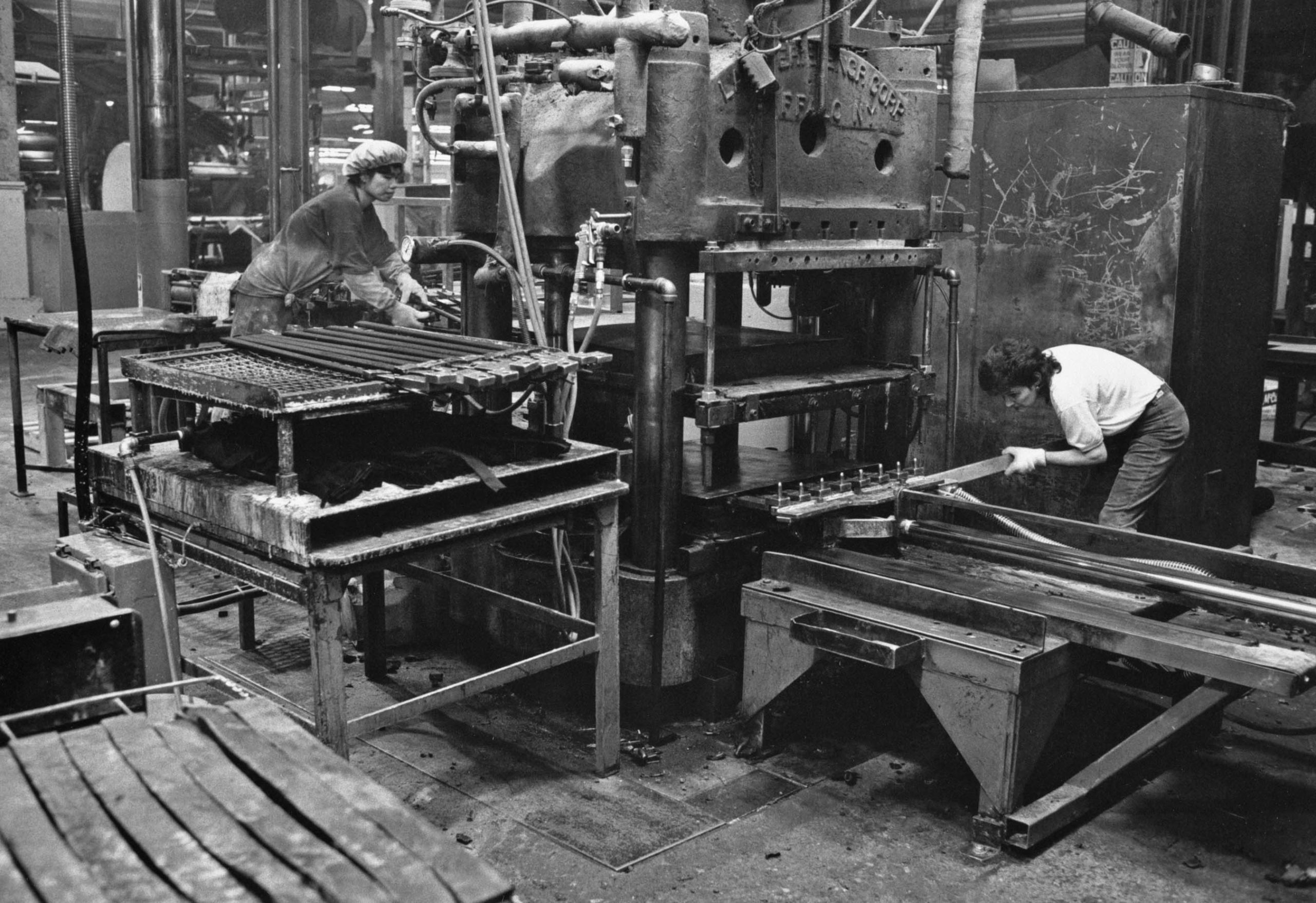 Ling Co and Nivia Simao moulding automotive parts on an older press, Department 54, May, 1993