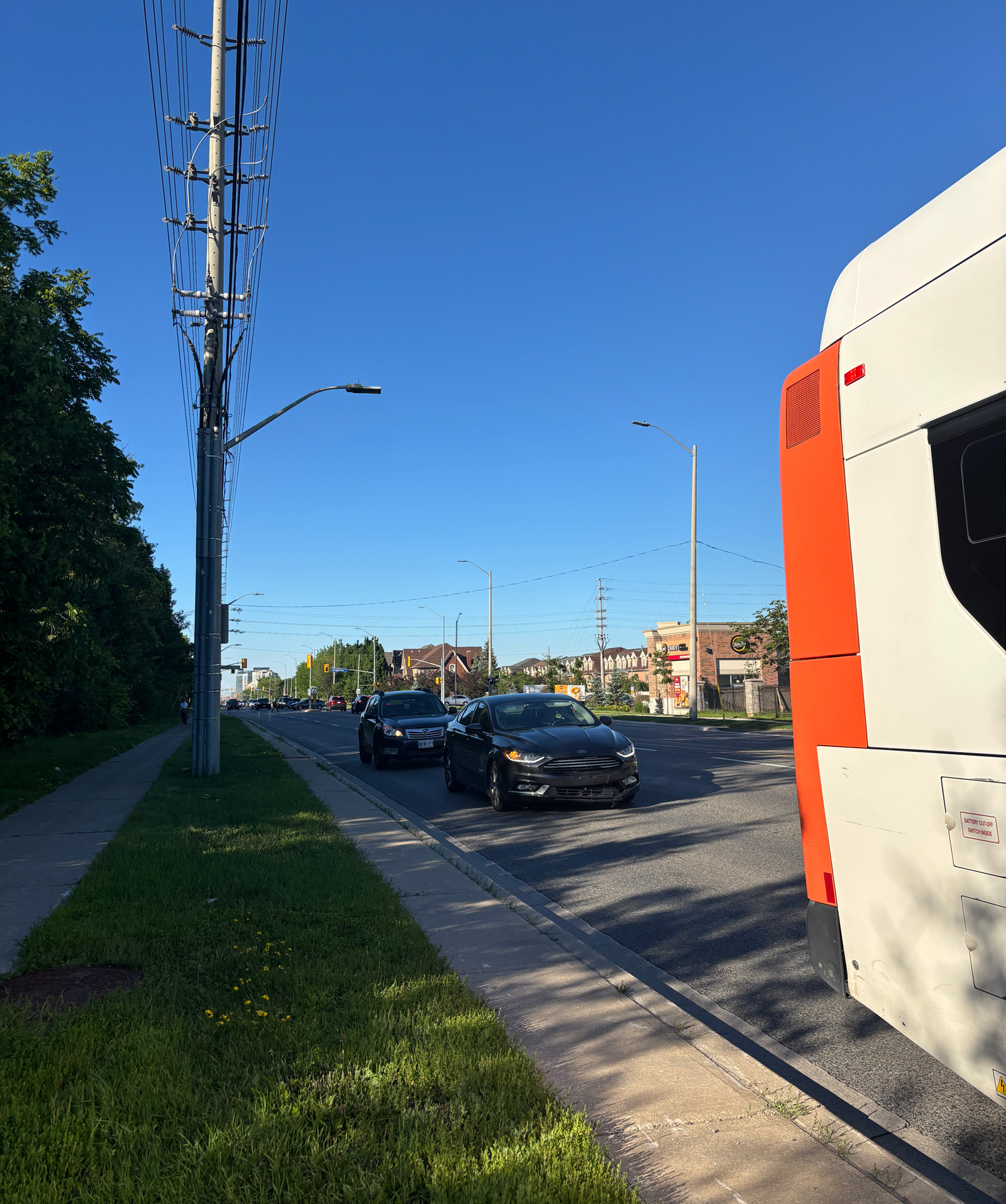 View from the bus stop. Ridgeway Plaza seen to the right, residential sidewalk to the left.