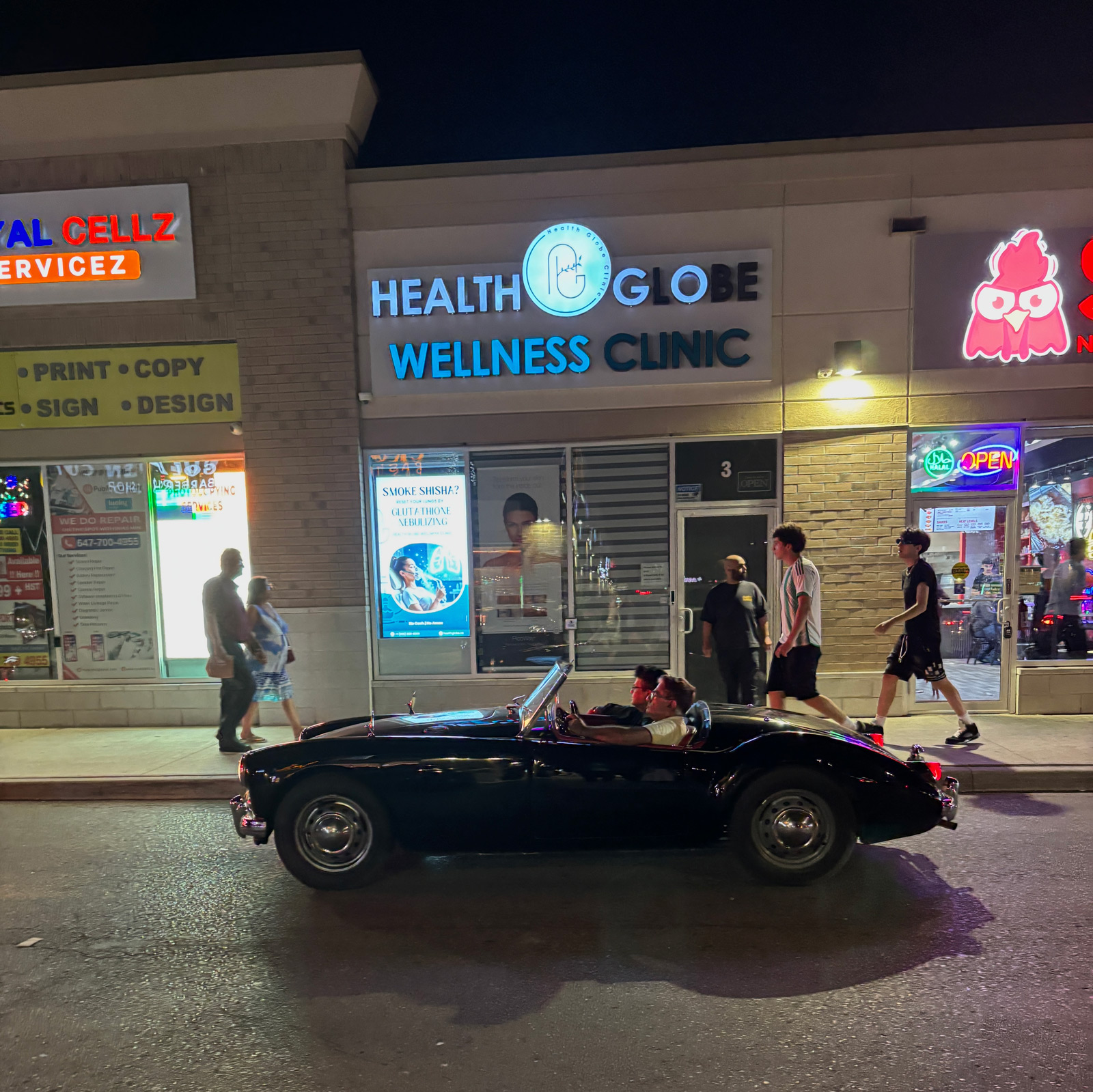 Cars and people intertwine around the businesses
