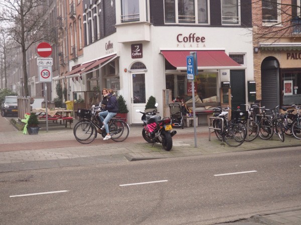 A separated bike lane next to retail. 