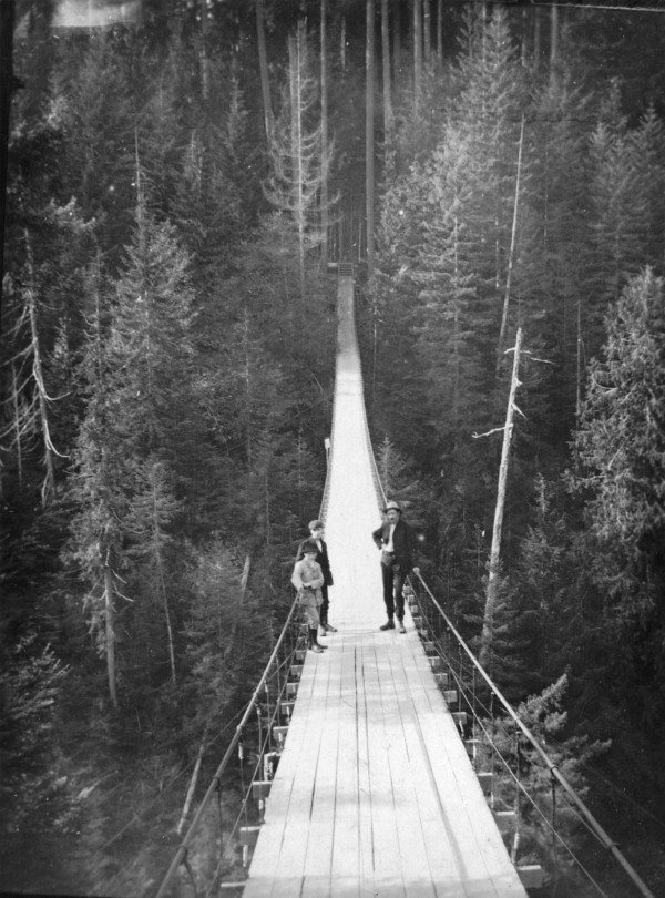 CVA 677-62 Three people crossing the Capilano Suspension Bridge, 1910. 