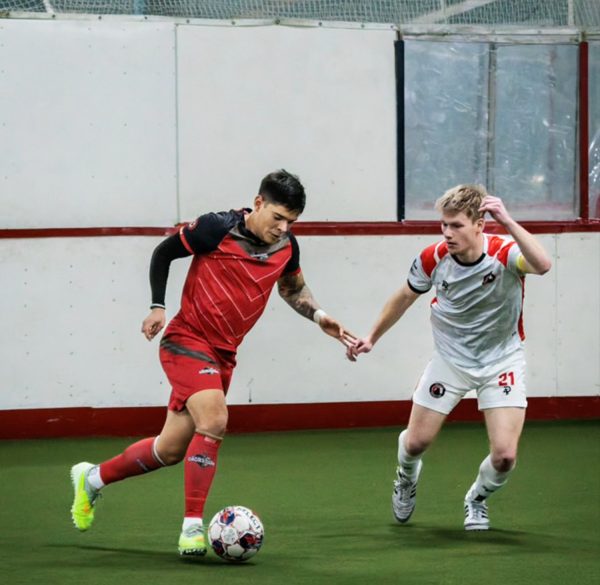 An indoor soccer player moves the ball