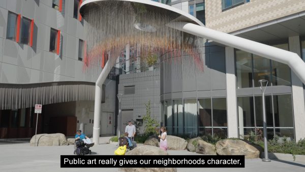 Still from the video Art of Maintenance showing people observing public artwork