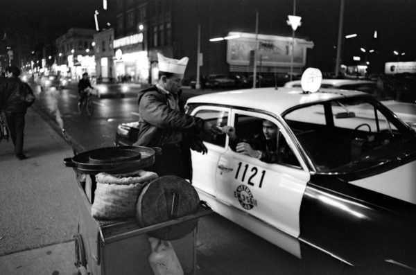 Vendor handing chestnuts to taxi cab driver on Yonge Street